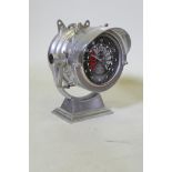 A polished aluminium cased clock in the form of a searchlight, with ship's telegraph style dial