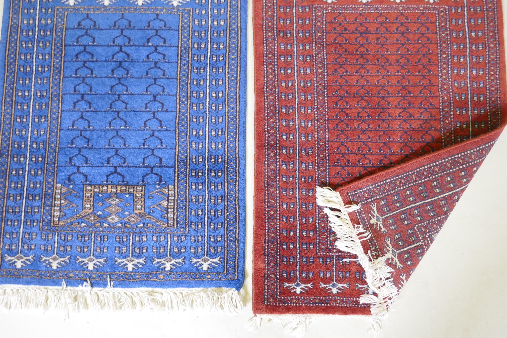 An oriental hand woven wool prayer rug with geometric designs on a red field and another in blue, - Image 2 of 2