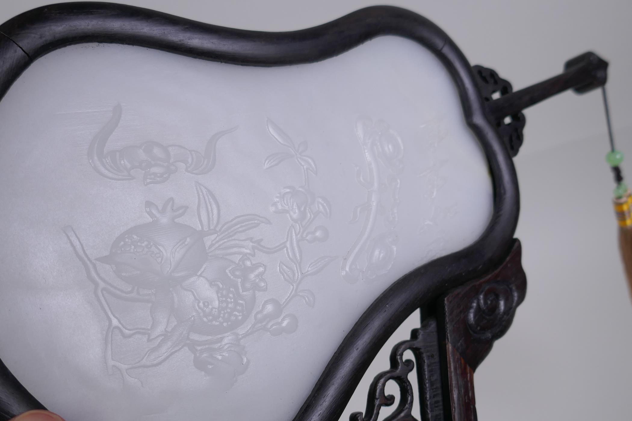 A Chinese white jade hand fan with carved pomegranate, bat and ruyi decoration, on a carved and - Image 3 of 3