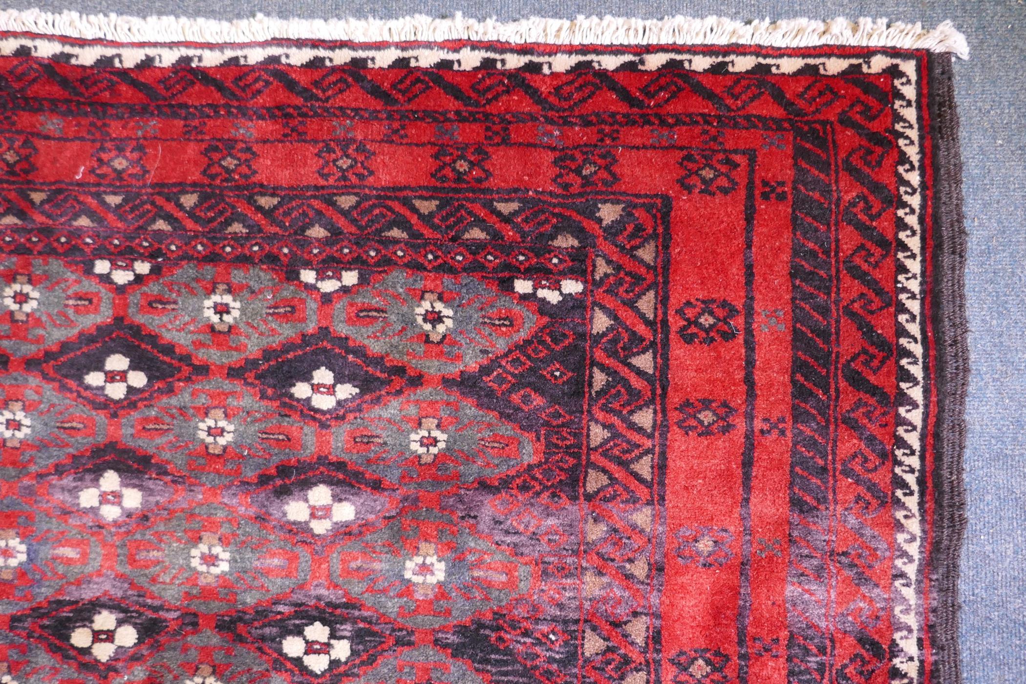A full pile hand woven red ground carpet with a geometric floral design, 268 x 130cm - Image 3 of 4