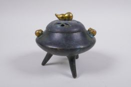 A Chinese bronze censer and cover on tripod supports with gilt gourd handles and knop impressed seal
