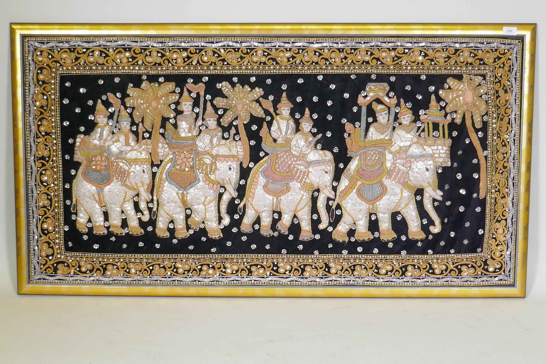 An Indian stumpwork depicting a procession with elephants, mounted in a gilt frame, 82 x 155cm