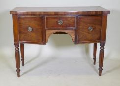 A Regency mahogany bow fronted kneehole sideboard with a cross banded top and three drawers,
