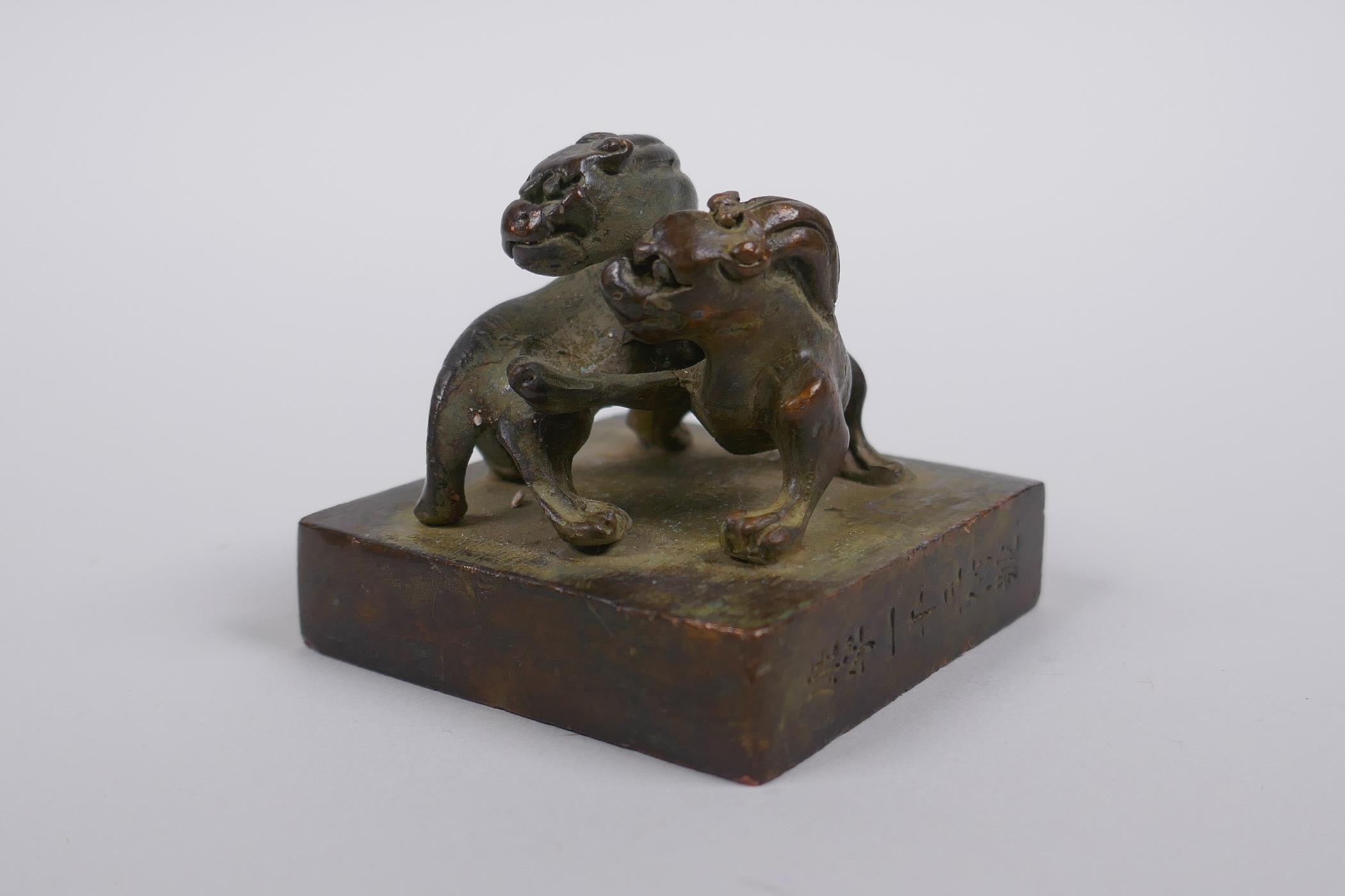A Chinese bronze seal decorated with two entwined kylin, 5 x 5cm