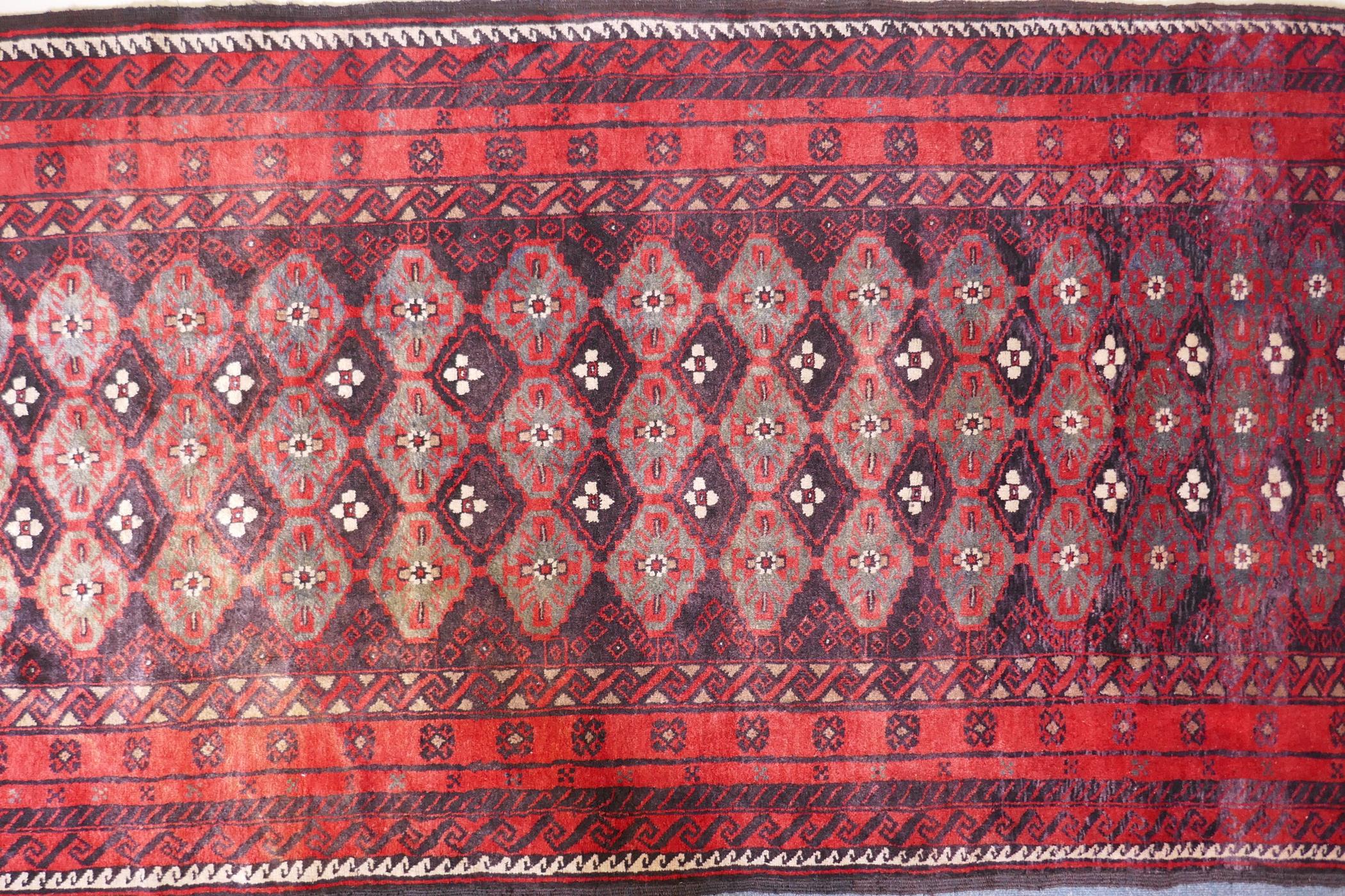 A full pile hand woven red ground carpet with a geometric floral design, 268 x 130cm - Image 2 of 4