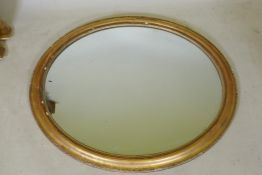 A gilt framed oval wall mirror, 89cm x 78cm