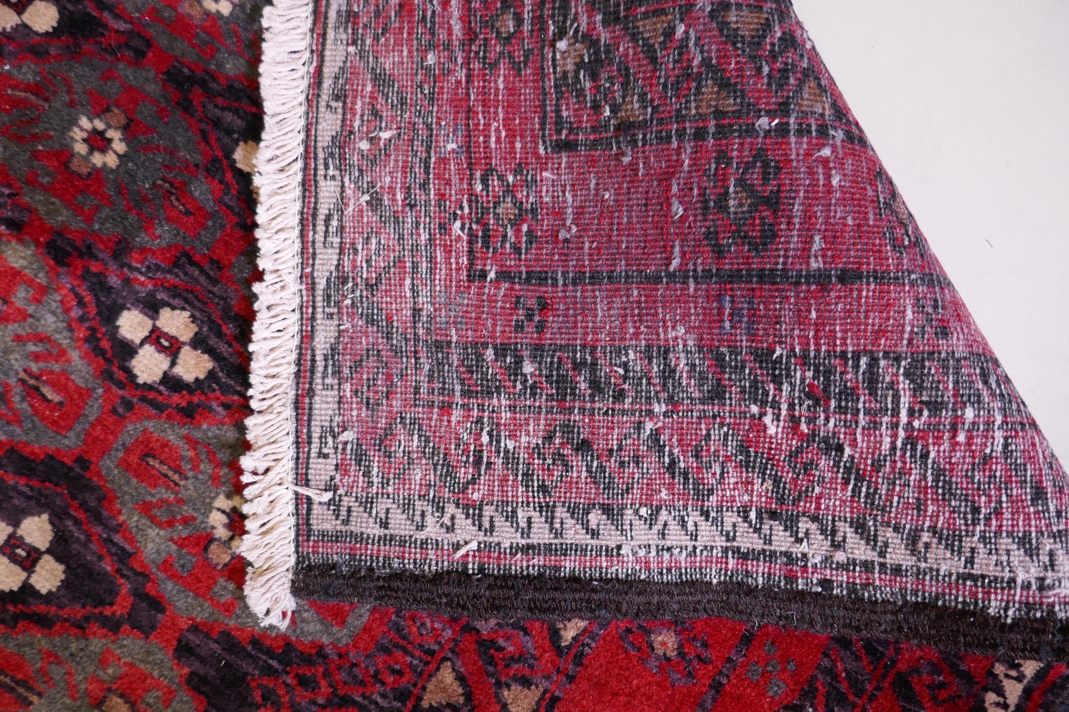 A full pile hand woven red ground carpet with a geometric floral design, 268 x 130cm - Image 4 of 4