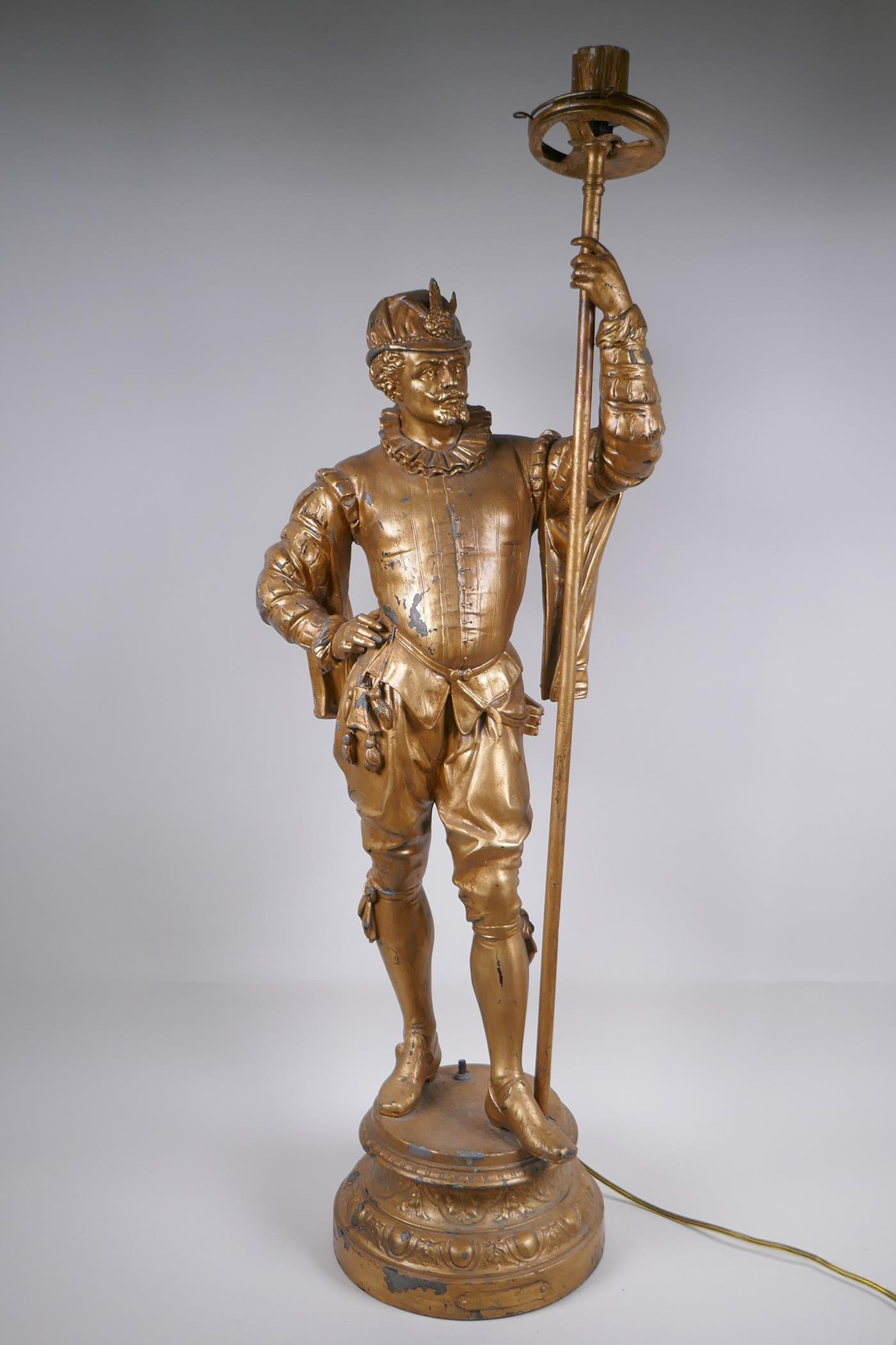 A gilt spelter figural lamp in the form of a Renaissance gentleman, 86cm high