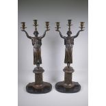 A pair of Empire style bronze three branch figural candlesticks in the form of classical women, 74cm