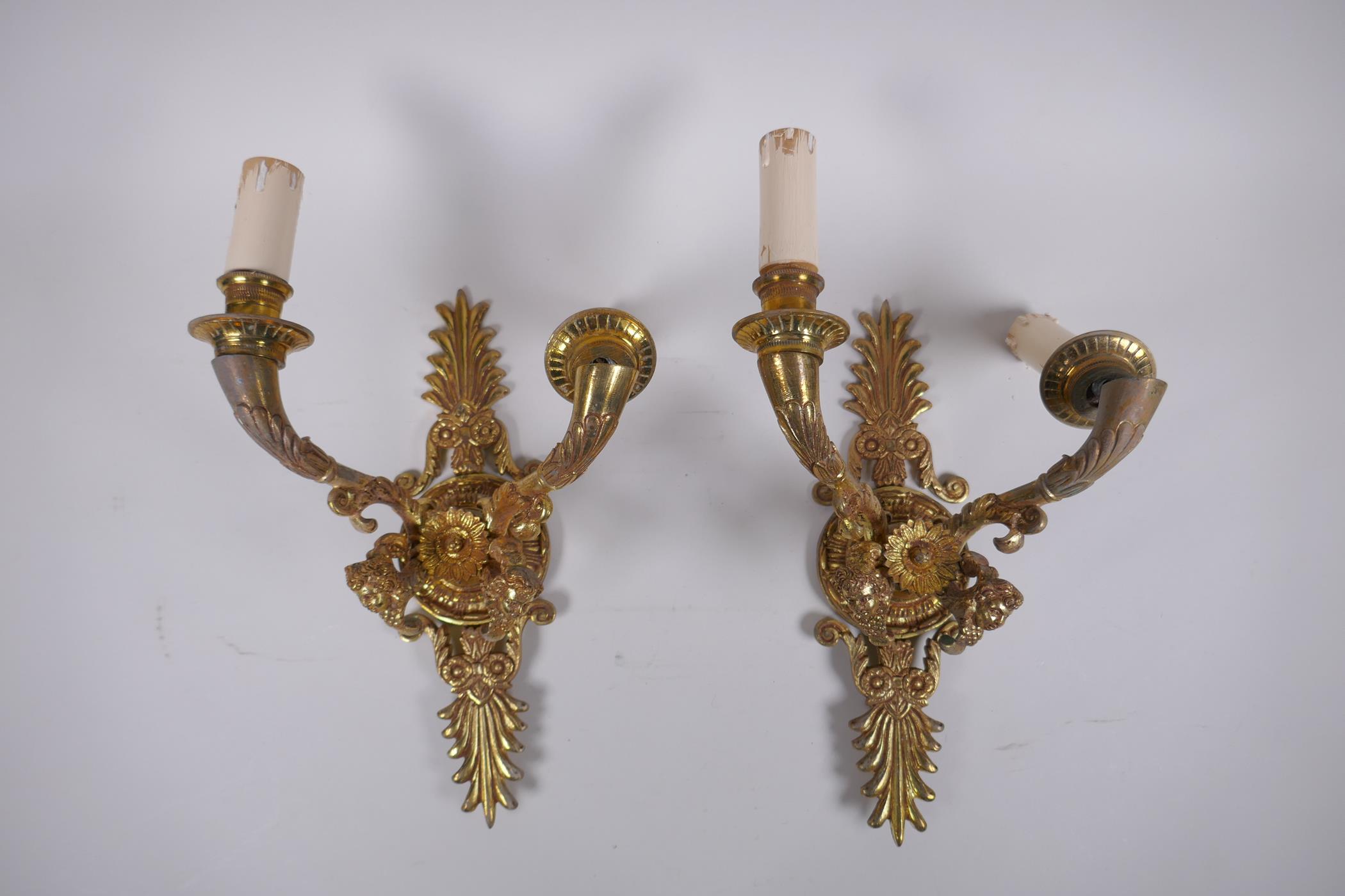 A pair of ormolu two branch wall sconces with putti mask decoration, 30cm high