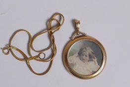 A yellow metal circular locket, marks rubbed, probably 9ct, 7.7g, on a 14ct gold plated chain, 4cm