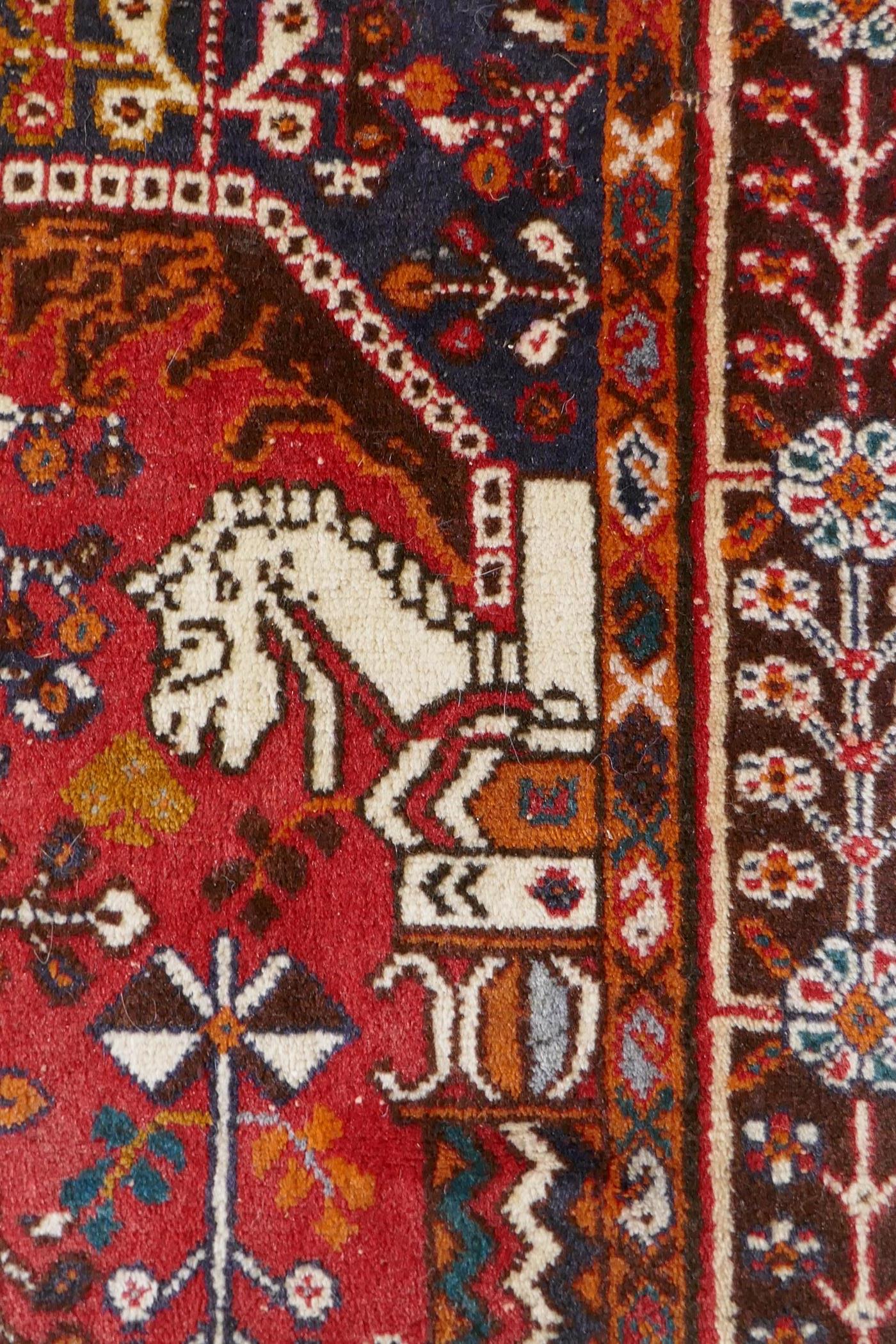 A hand woven red ground Persian carpet decorated with a geometric medallion, birds and camels, 158 x - Image 5 of 6