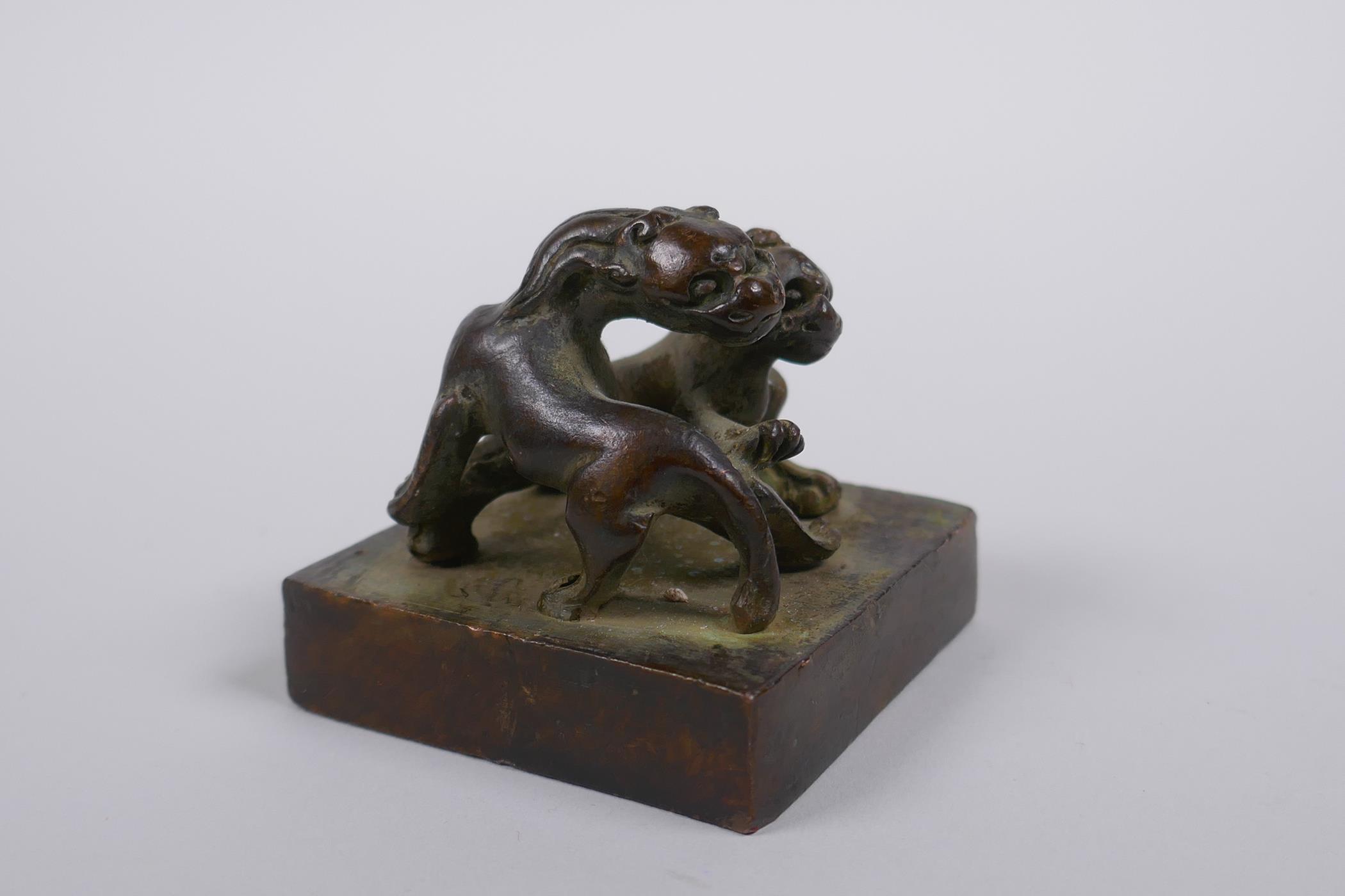 A Chinese bronze seal decorated with two entwined kylin, 5 x 5cm - Image 2 of 4