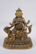 A Sino Tibetan gilt bronze figure of a deity seated on the back of a kylin, 23cm high