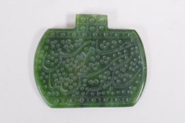 An Islamic spinach jade pendant with chased Islamic script decoration, 6 x 5cm