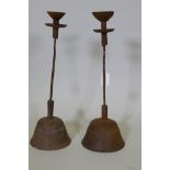 A pair of antique cast iron candlesticks, 42cm high