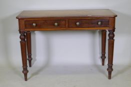 An early C19th mahogany writing table with two drawers, raised on tapering turned supports, 107 x