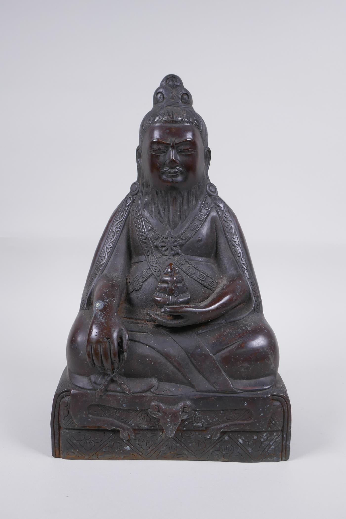 A Sino Tibetan bronze figure of a bearded deity seated in meditation, 29cm high