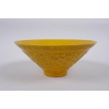 A Chinese yellow ground porcelain bowl of conical form with raised twin dragon decoration, impressed