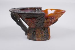 A Chinese section horn libation cup with carved decoration of figures in a landscape, 19 x 15cm,
