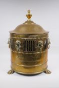 An antique brass coal scuttle with two lion mask loop handles, rams mask decoration and pawed