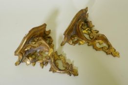 A pair of carved giltwood rococo style wall brackets, losses to one, 20cm long