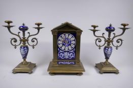 A C19th French bronze and enamelled porcelain clock garniture, the hand painted dialÿ with mask