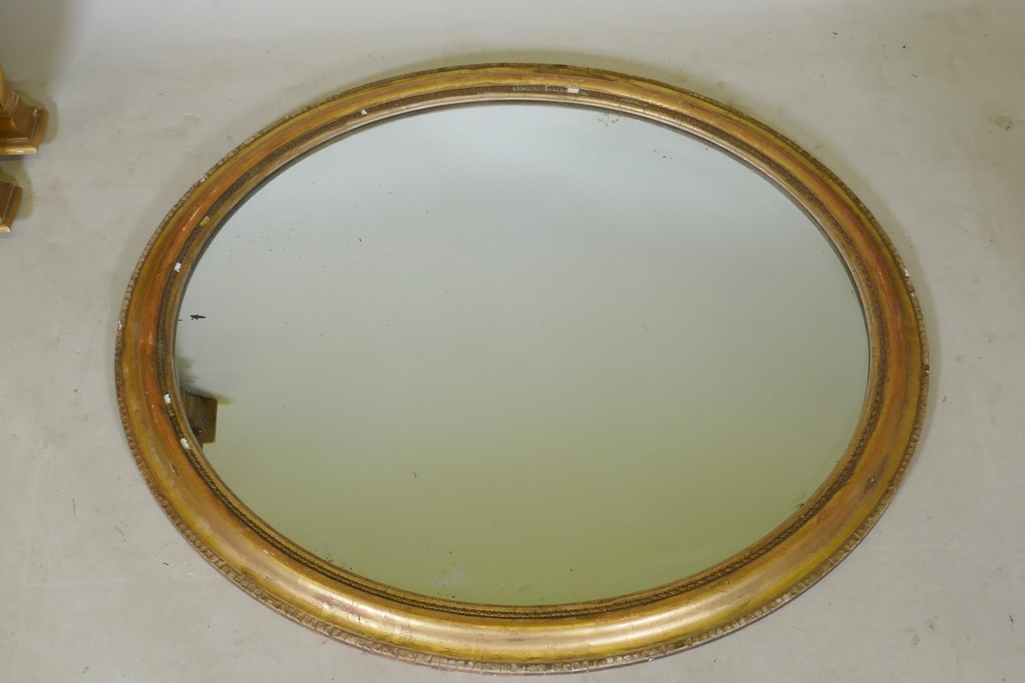 A gilt framed oval wall mirror, 89cm x 78cm