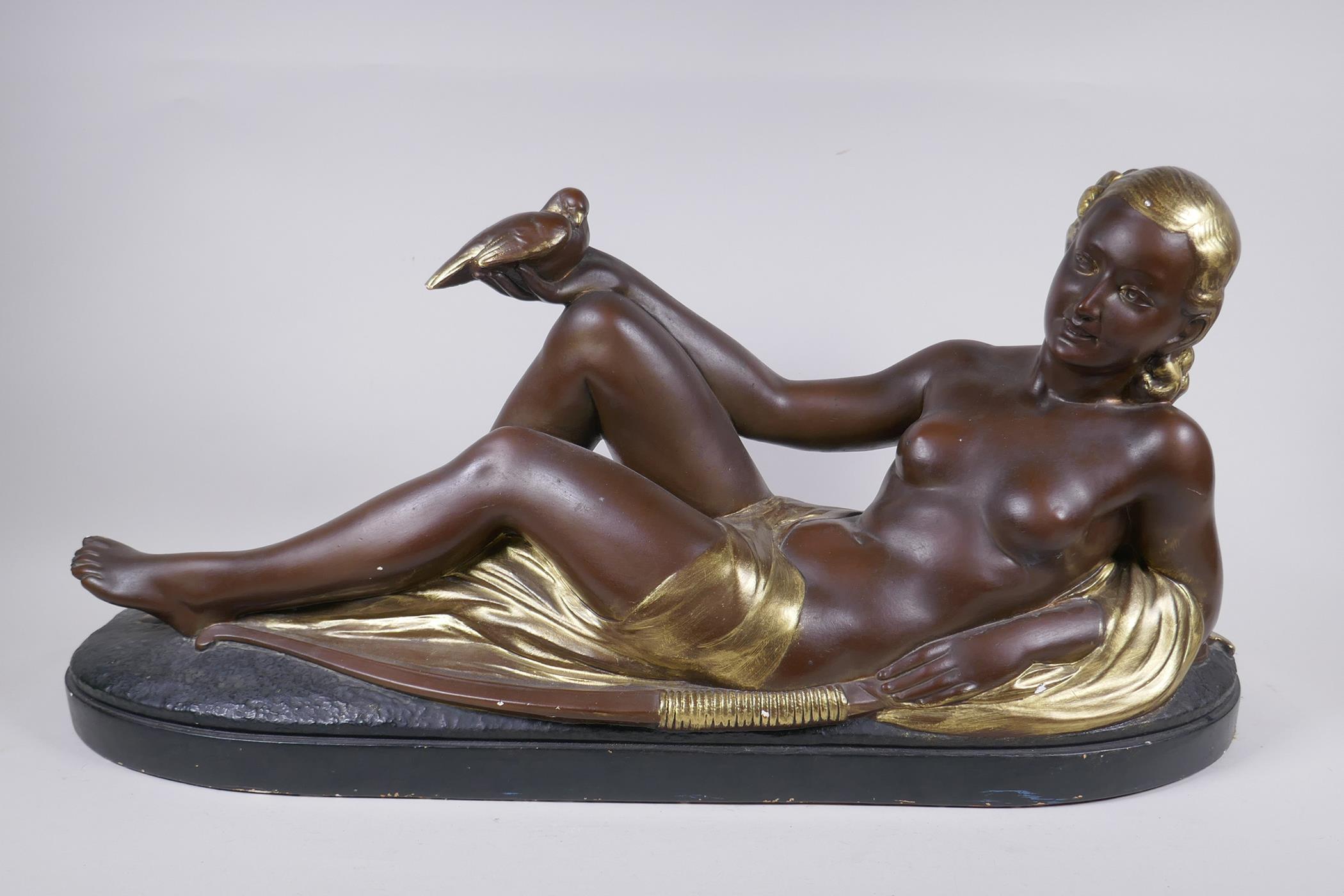 A bronzed and gilt plaster figure of a reclining female nude, 75cm long, 35cm high