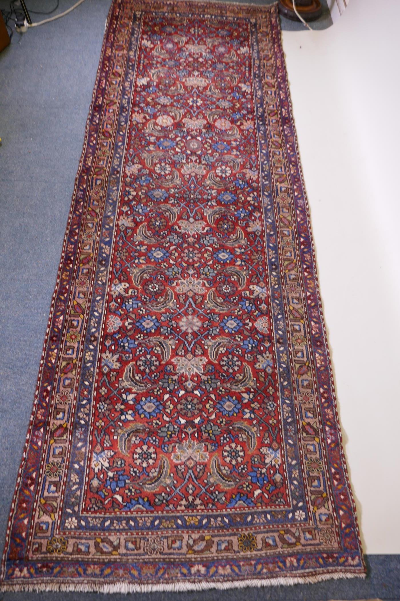 A hand woven red ground Persian Hamadan nomadic runner with an allover floral design, 102 x 310cm - Image 3 of 6