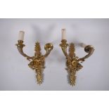 A pair of ormolu two branch wall sconces with putti mask decoration, 30cm high