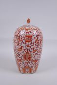 An early C20th Chinese iron red and white porcelain jar and cover with lotus flower decoration, 25cm