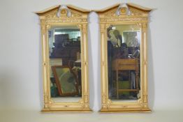 A pair of Regency style painted composition wall mirrors, with broken pediment tops and anthemion