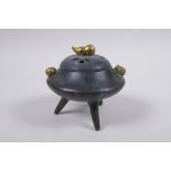 A Chinese bronze censer and cover on tripod supports with gilt gourd handles and knop impressed seal