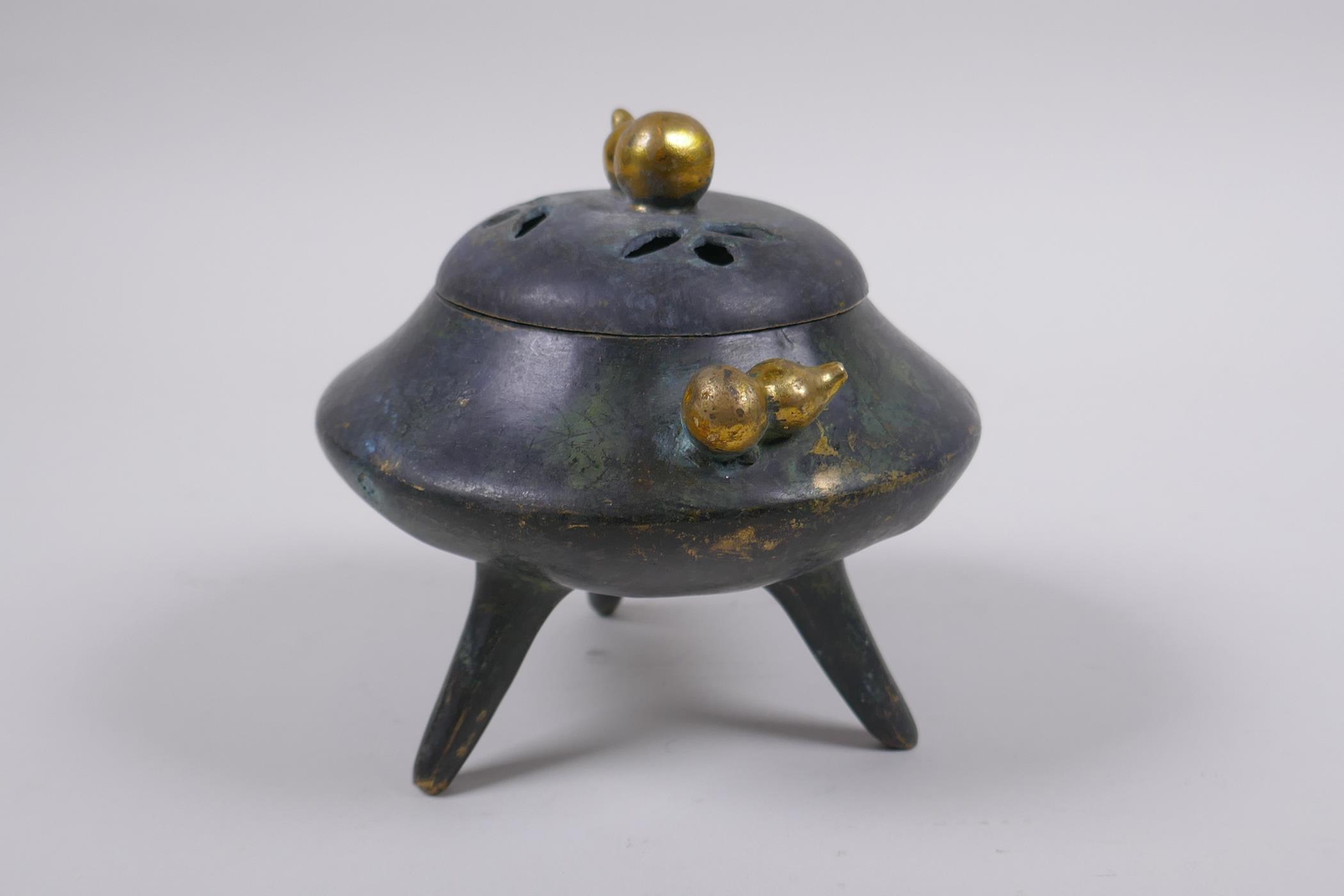 A Chinese bronze censer and cover on tripod supports with gilt gourd handles and knop impressed seal - Image 4 of 5