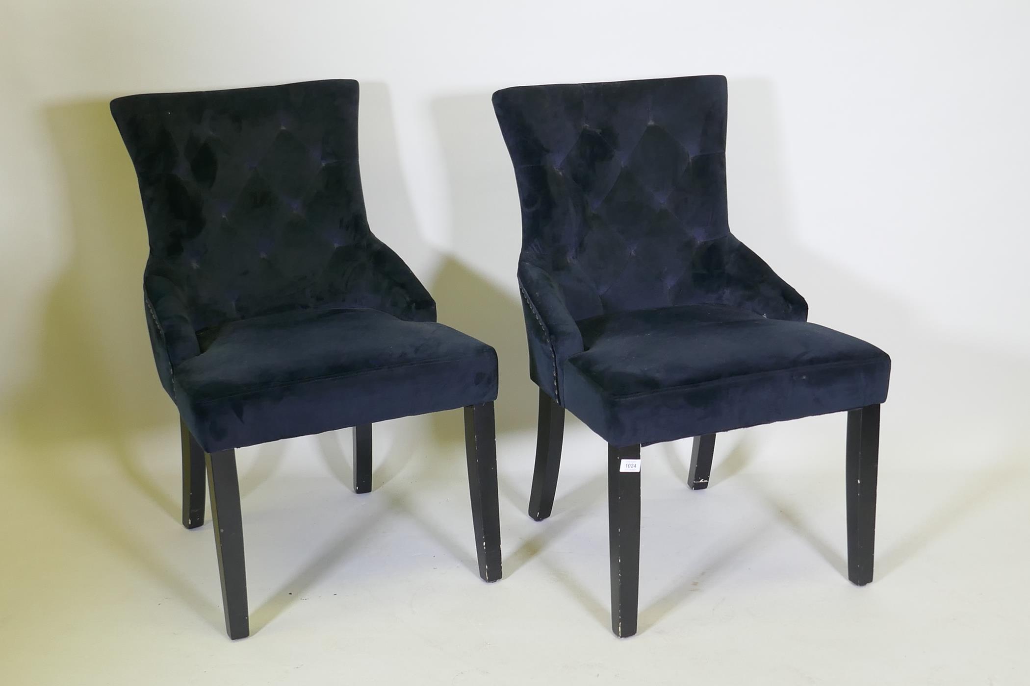 A pair of velvet side chairs with a decorative metal ring knocker to back
