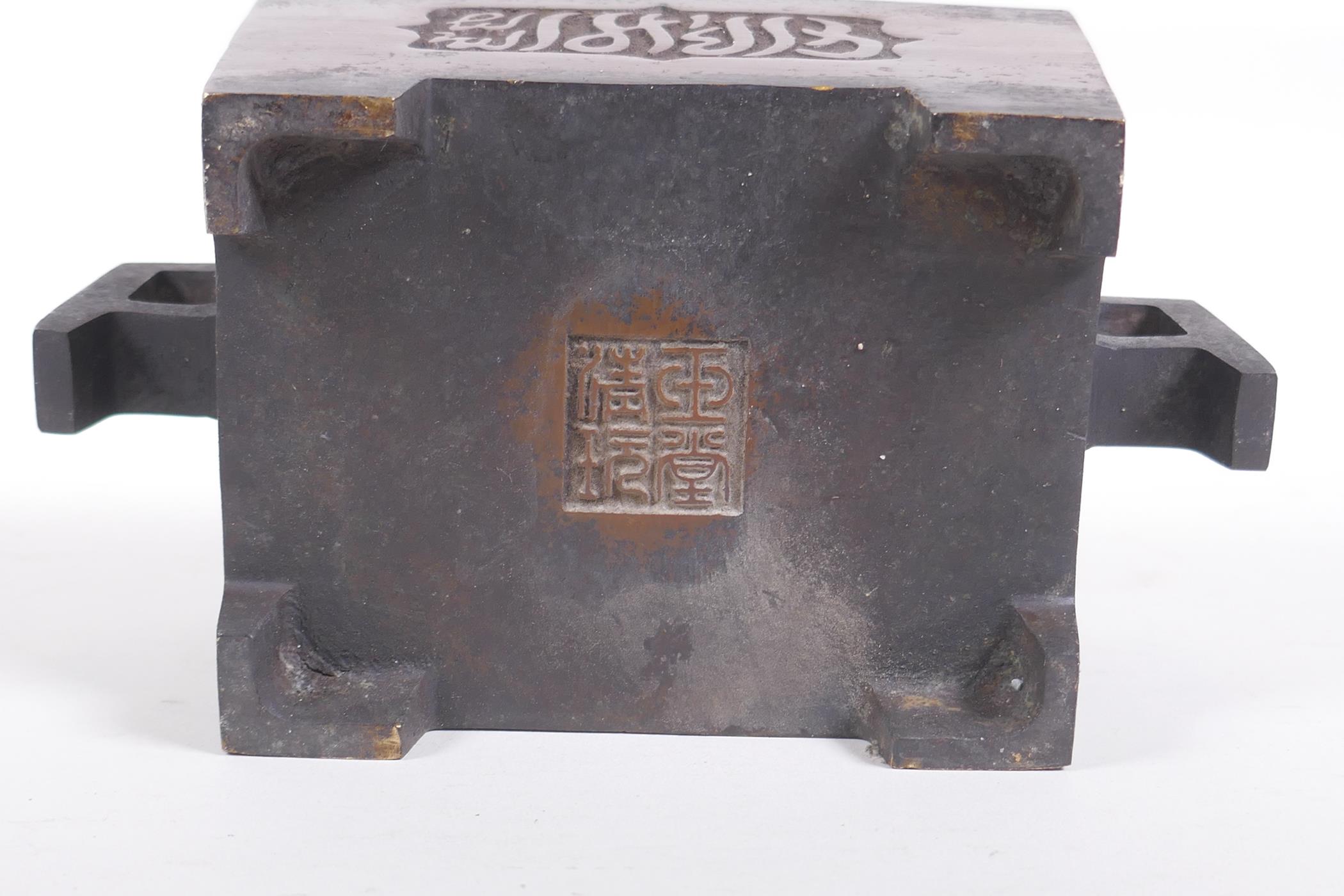 A Chinese bronze two handled censer with decorative script panels, impressed seal mark to base, 19 x - Image 4 of 5