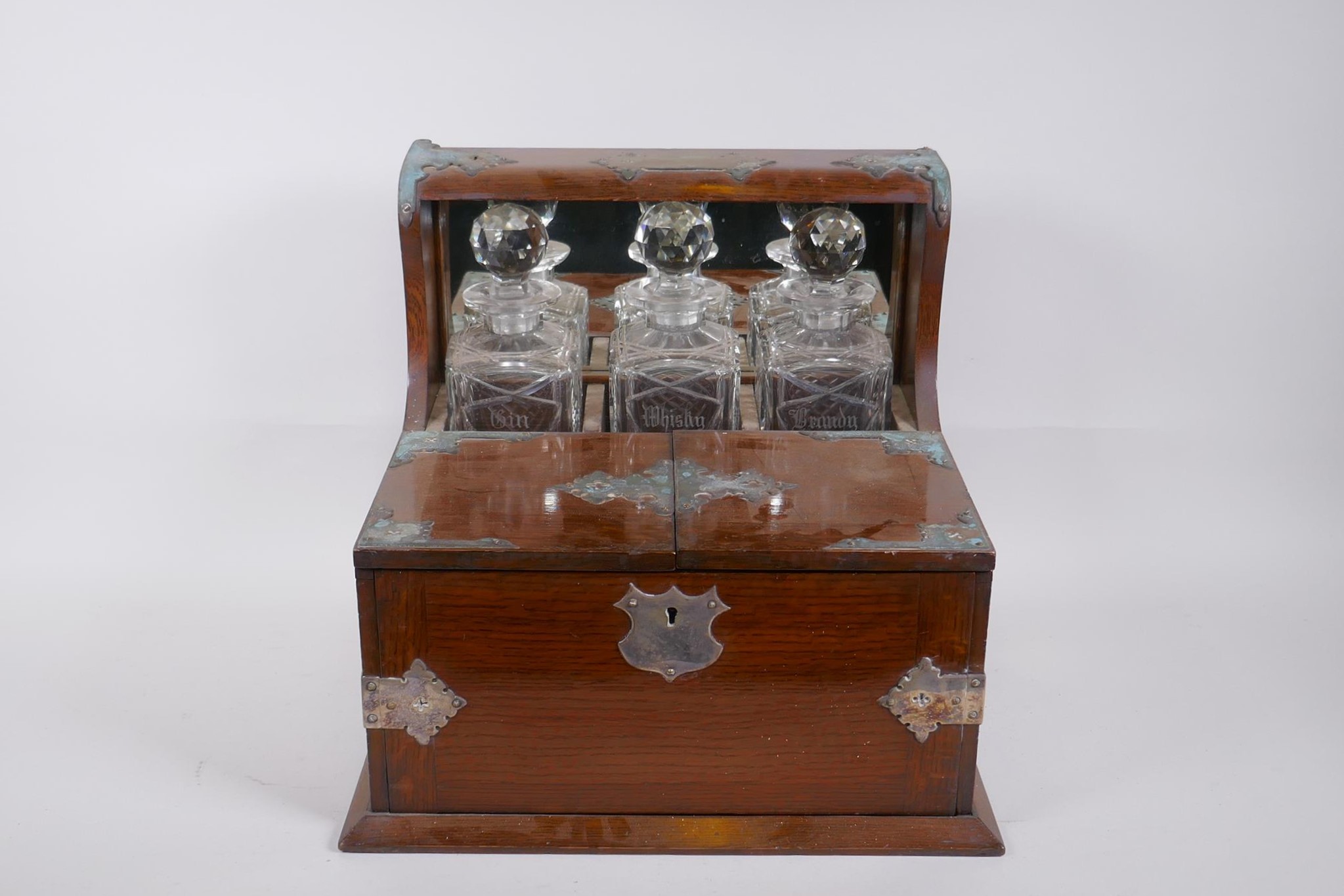 A Victorian oak and silver plated three bottle tantalus, opening to reveal fitted compartments, - Image 2 of 3