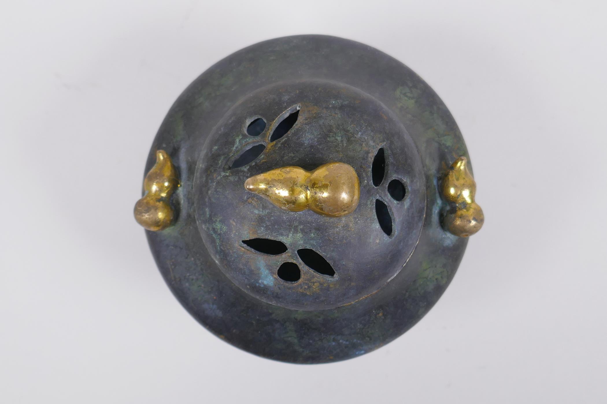 A Chinese bronze censer and cover on tripod supports with gilt gourd handles and knop impressed seal - Image 2 of 5