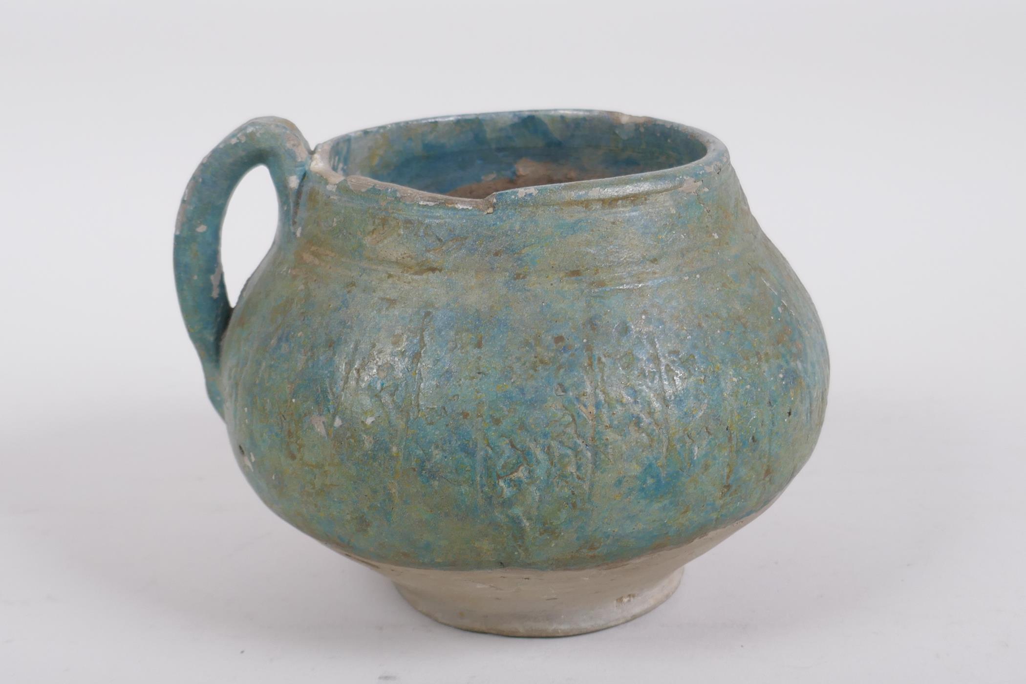An antique turquoise slip glazed terracotta pot with a single handle, historic repairs, 14cm