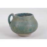 An antique turquoise slip glazed terracotta pot with a single handle, historic repairs, 14cm