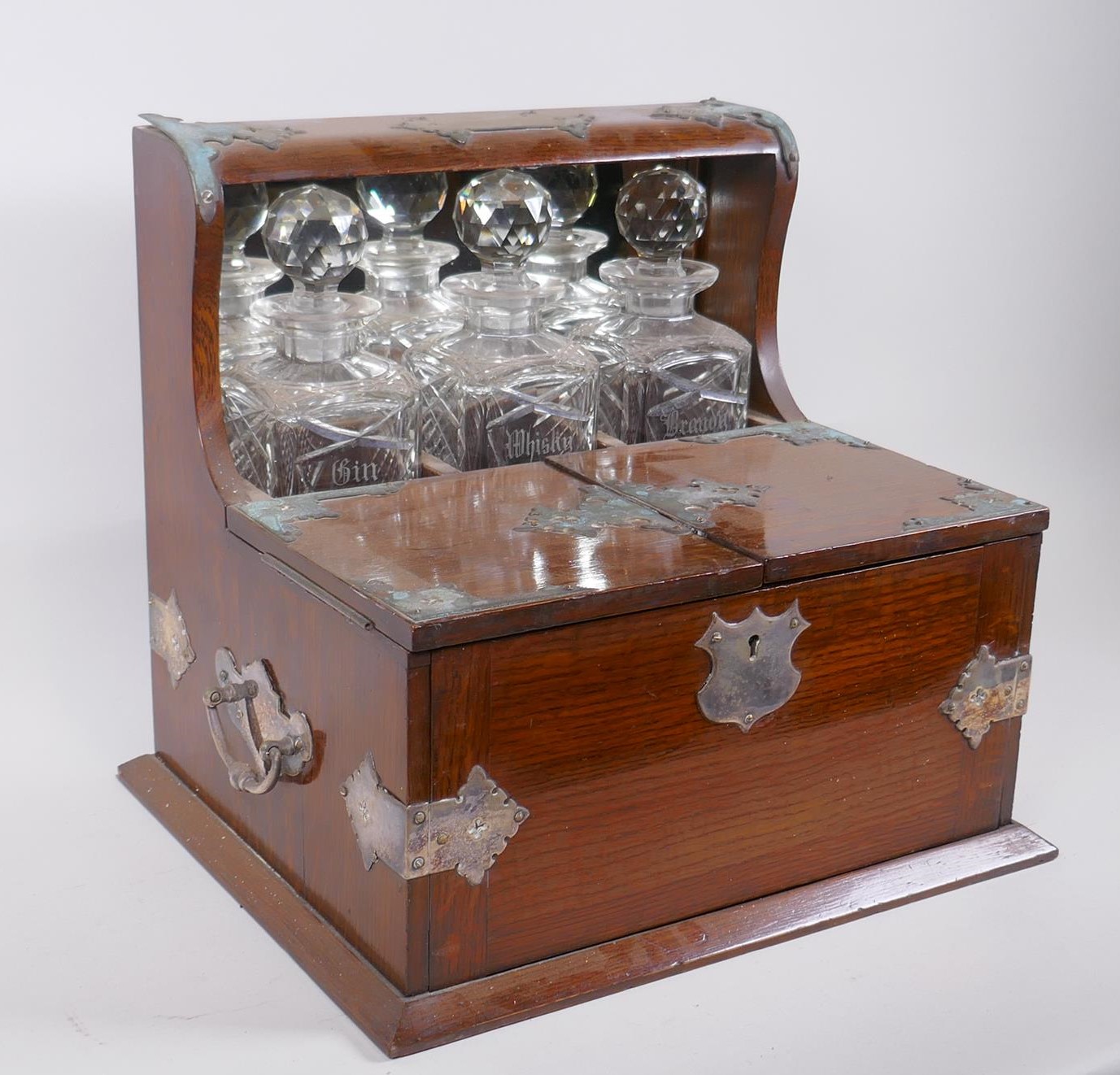 A Victorian oak and silver plated three bottle tantalus, opening to reveal fitted compartments, - Image 3 of 3