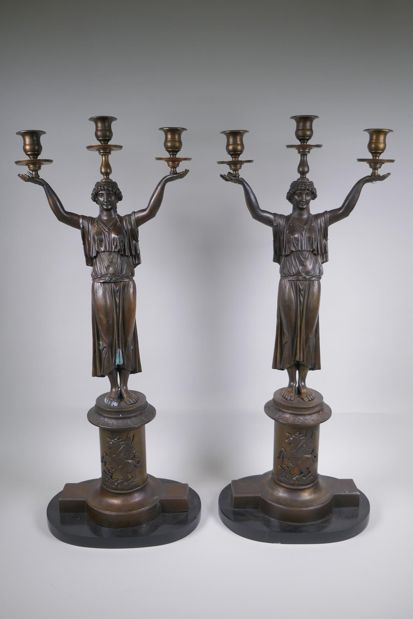 A pair of Empire style bronze three branch figural candlesticks in the form of classical women, 74cm