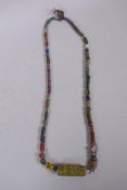 An Islamic multicolour glass bead necklace with a mille fiori feature bead, 88cm long