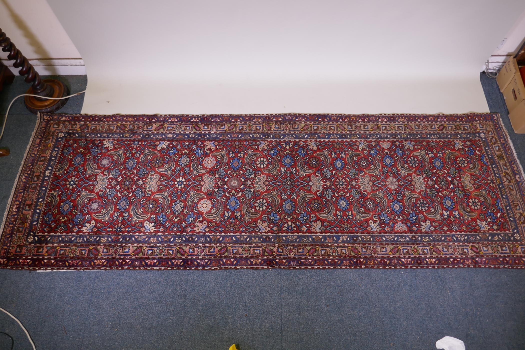 A hand woven red ground Persian Hamadan nomadic runner with an allover floral design, 102 x 310cm - Image 2 of 6