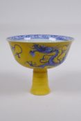 A Chinese yellow ground porcelain stem bowl with blue and white dragon decoration, 10cm high x