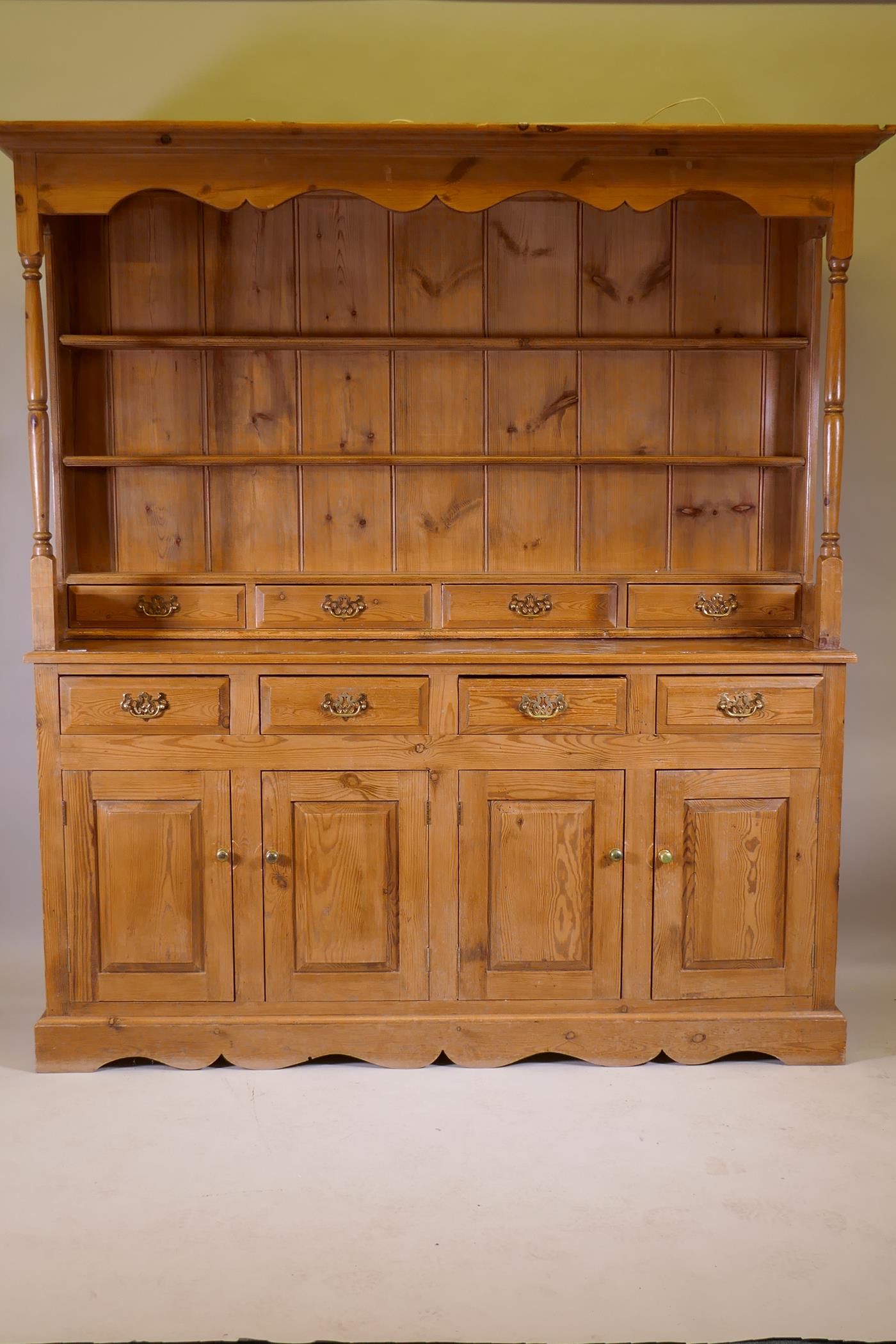 A pine dresser, the upper section with delft rack over four drawers, open sides, the base with