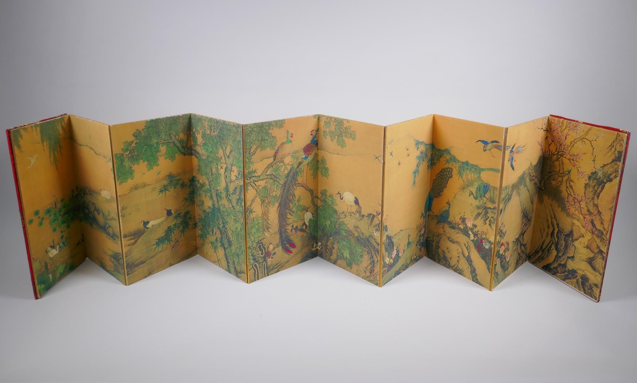 A Chinese printed concertina book depicting an extensive landscape with numerous asiatic birds, 18 x