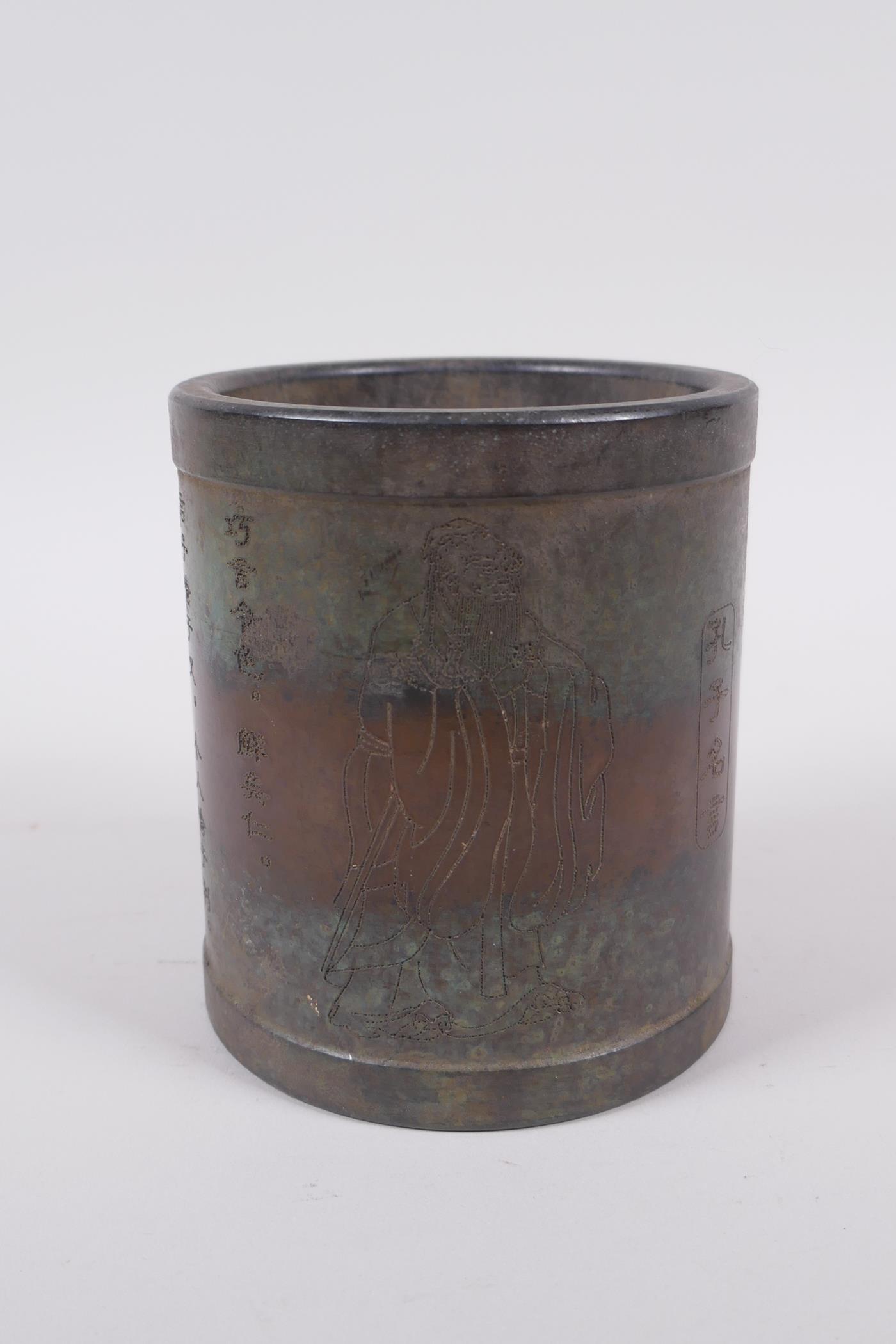 A Chinese bronze brush pot with Lohan and character decoration, impressed mark to base, 11cm high,