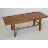A mid century coffee table, with gallery top, raised on square supports united by stretchers, 114
